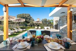 a table with food on it next to a pool at Drakos Estate - Luxury Pool Villas in Asgourou