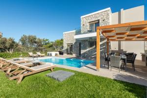a backyard with a swimming pool and a house at Drakos Estate - Luxury Pool Villas in Asgourou