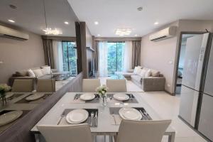a kitchen and living room with a table and chairs at Spacious 2BR Condo with 2 Balconies in Sukhumvit16 in Bangkok