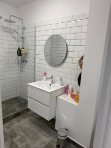 a white bathroom with a sink and a mirror at Central Studio Yoko , Craiova in Craiova