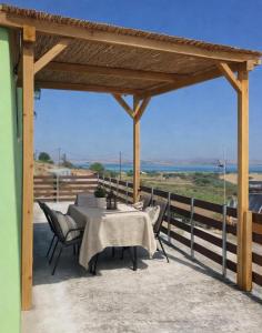 a table and chairs on a patio with a view of the ocean at Vasileris Home in Moúdhros