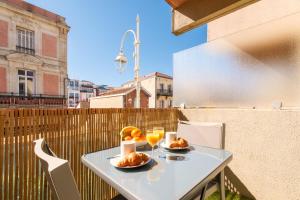 a table with two plates of food and drinks on a balcony at La Pomponnette du Bassin in Arcachon +19 photos