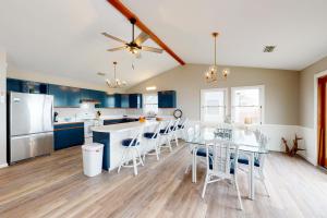 a kitchen with blue cabinets and a table and chairs at Rylander-Timmerman House OBX in Nags Head