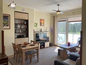a living room with a table and a television at Aquamarina Turkus Apartament 253 in Międzyzdroje
