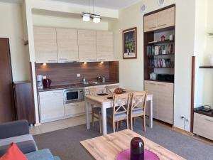 a kitchen with a table and chairs in a room at Aquamarina Turkus Apartament 253 in Międzyzdroje