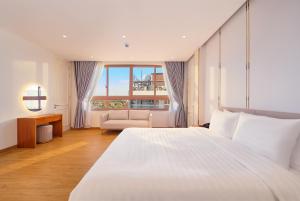 a bedroom with a large white bed and a couch at Cát Tường Hotel in Da Lat +59 photos