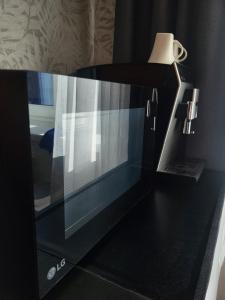 a microwave oven sitting on top of a table at Narva Apartments in Narva +8 photos