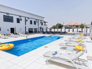 a pool with chaise lounge chairs and a resort at Peregrine Hotel Jos in Jos