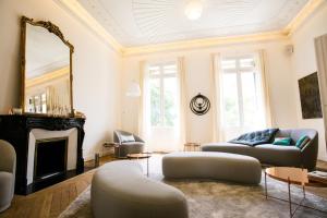 a living room with two couches and a fireplace at L'Hôtel Particulier Beziers in Béziers