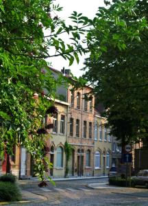 ein großes Backsteingebäude auf einer Straße mit Bäumen in der Unterkunft De Buur Van Beer in Ypern