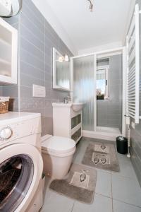 a bathroom with a toilet and a washing machine at Marina Bay Apartment in Zadar