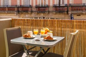 a table with two glasses of orange juice and croissants on a balcony at La Pomponnette du Bassin in Arcachon