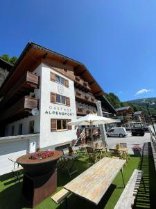 a building with a table and a bench in front of it at Gasthof Alpensport - inklusive Joker Card in Saalbach-Hinterglemm