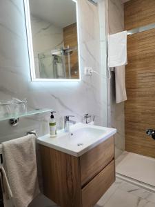 ein weißes Badezimmer mit Waschbecken und Dusche in der Unterkunft Csórtok in Lug