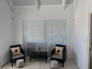 a room with two chairs and a table and a window at The Tides Holiday Home in St. Helena Bay +28 photos