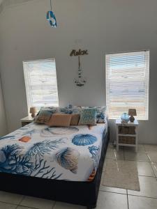 a bedroom with a bed in a room with windows at The Tides Holiday Home in St. Helena Bay