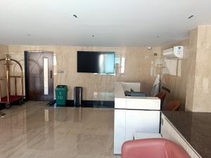 a lobby with a flat screen tv on a wall at Crystal Residency - Panjappur Trichy in Pūngudi +31 photos