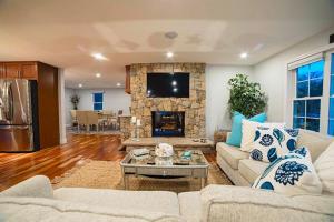 a living room with two couches and a stone fireplace at Beachside family POOLSPAOPEN20thAPril in Barnstable