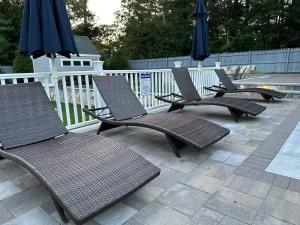 a group of chairs and umbrellas on a patio at Beachside family POOLSPAOPEN20thAPril in Barnstable