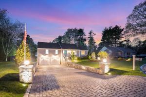 a driveway leading to a garage with an american flag at Beachside family POOLSPAOPEN20thAPril in Barnstable +90 photos