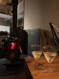two glasses of white wine sitting on a wooden table at Maison N in Shimoda +14 photos