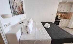 a white bed with pillows on it in a room at Yposkafo Suites - Private Studio - Santorini in Fira