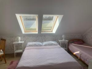 a bedroom with a bed and two windows at Noclegi Bajama in Siepraw +63 photos