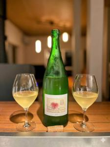 two wine glasses sitting next to a bottle of wine at Maison N in Shimoda