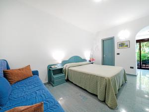 a bedroom with a bed and a blue couch at Baia Tropea in Fitili