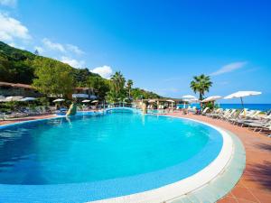a large swimming pool with chairs and umbrellas at Baia Tropea in Fitili +21 photos