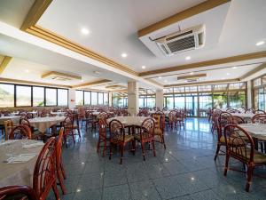 a dining room with tables and chairs and windows at Baia Tropea in Fitili