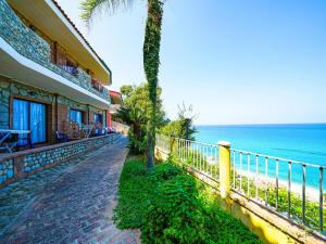 a building next to the beach with a palm tree at Baia Tropea in Fitili