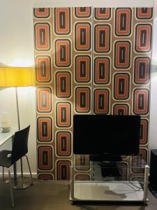 a living room with a tv and a wall with a wall gmaxwell gmaxwell at Stylish studio 3-4p with AC and balcony near Champs-Élysées in Paris