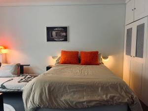 a bedroom with a bed with orange pillows on it at Stylish studio 3-4p with AC and balcony near Champs-Élysées in Paris