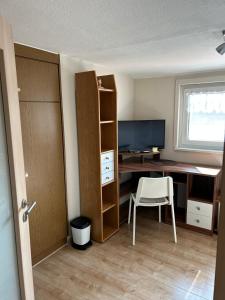 a room with a desk with a computer and a chair at Ferienwohnung Uschi 1 in Peiting