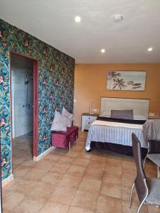 a hotel room with a bed and a chair at Wonderland Villa Tierra Fértil Los Gigantes in Santiago del Teide