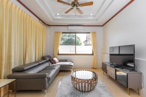 a living room with a couch and a television at Villa Natali between Rawai and Nai Harn in Rawai Beach