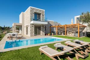 a villa with a swimming pool and a patio at Drakos Estate - Luxury Pool Villas in Asgourou