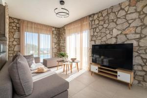 a living room with a stone wall at Drakos Estate - Luxury Pool Villas in Asgourou