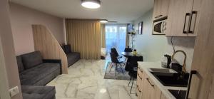 a kitchen and living room with a couch and a table at Apartamentai Gintaras in Palanga +3 photos
