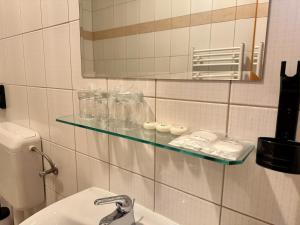 a bathroom with a glass shelf above a sink at Tamaris Rooms in Zadar +20 photos