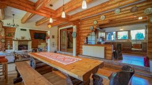 a dining room and living room with a wooden table at Dolce Cabana in Timisul de Jos