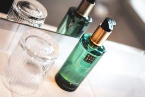 a bathroom sink with a bottle of soap and a glass at Villa Dora Petit Hôtel in Bad Reichenhall +59 photos