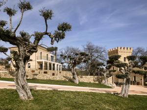 a house with trees in front of a building at Torre Zambra RESORT in Villamagna