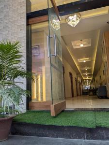a hallway of a building with a glass door and a plant at hotel Gautam Inn in Gorakhpur