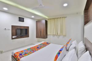 a bedroom with a bed and a tv on the wall at Hotel Nice RAILWAY STATION in Vadodara +29 photos