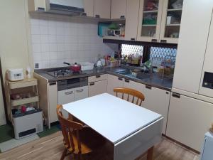 a kitchen with a table and a white counter top at YCS2 Guest house, good access to Shinjuku in Nishitokyo
