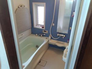 a bathroom with a tub and a window and a sink at YCS2 Guest house, good access to Shinjuku in Nishitokyo +16 photos
