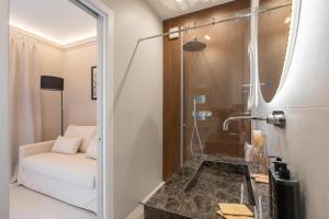 a bathroom with a shower and a white couch at Torre Saracena Massa Lubrense in Massa Lubrense +17 photos