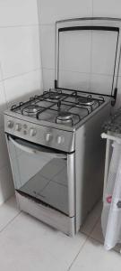 a stainless steel stove top oven in a kitchen at Apartamento de frente ao mar - Centro in Peruíbe
